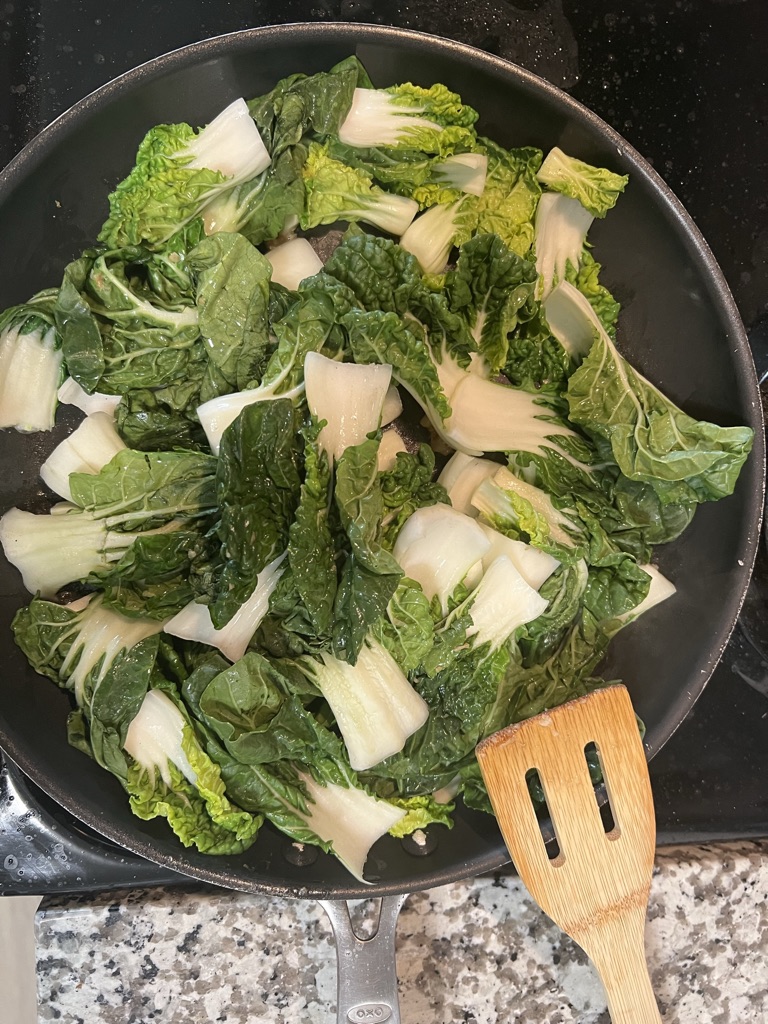 Adding bok choy to the pan